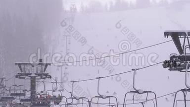 滑雪场滑雪电梯。 滑雪者在滑雪椅电梯上爬上滑雪坡，伴着降雪